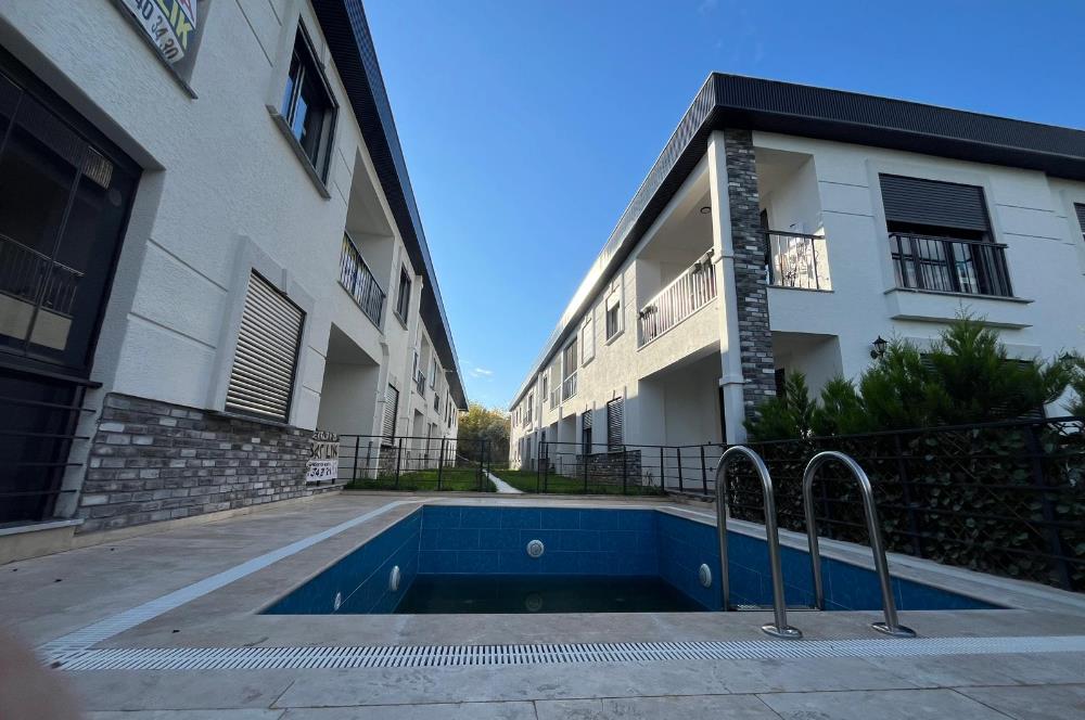 Güre Çamlıbel Zeytin Evleri’nde 1. Kat, Havuzlu, Bahçe Kullanımlı, Kapalı Otoparklı SATILIK DAİRE 1+1